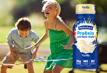 Boy drinking Chocolate PediaSure® shake with vitamins and other nutrients to help him grow.